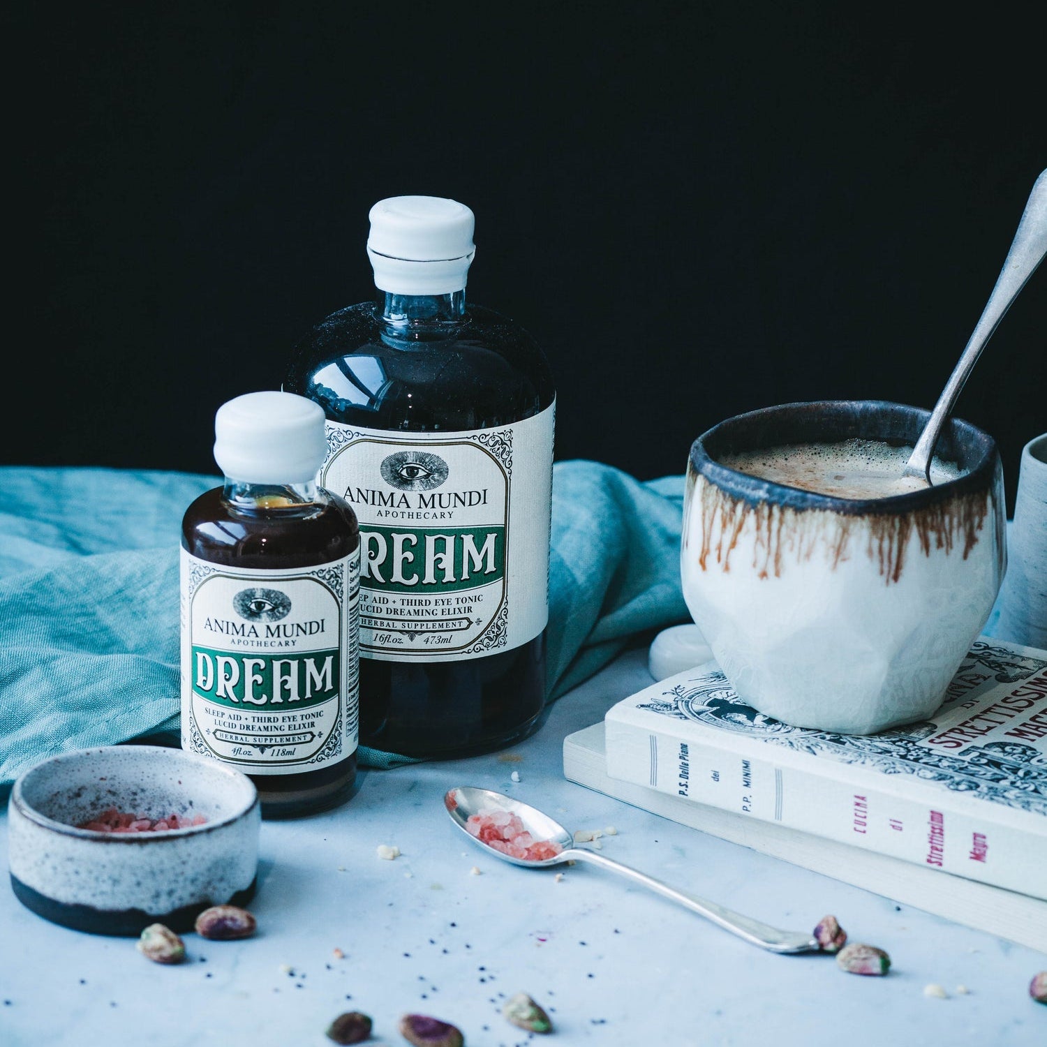 DREAM Elixir bottles with a ceramic cup and books, promoting rest and relaxation through adaptogens.