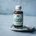 DREAM Elixir bottle on a stone plate, promoting rest, relaxation, and dreamtime awareness.