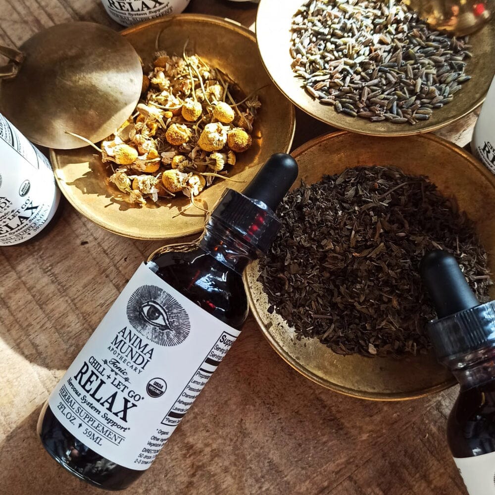 Bottle of 'Anima Mundi' relax tincture with herbs on a wooden surface