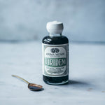 VIRIDEM Elixir bottle for daily detox support and mineralization with a spoon on a marble surface.
