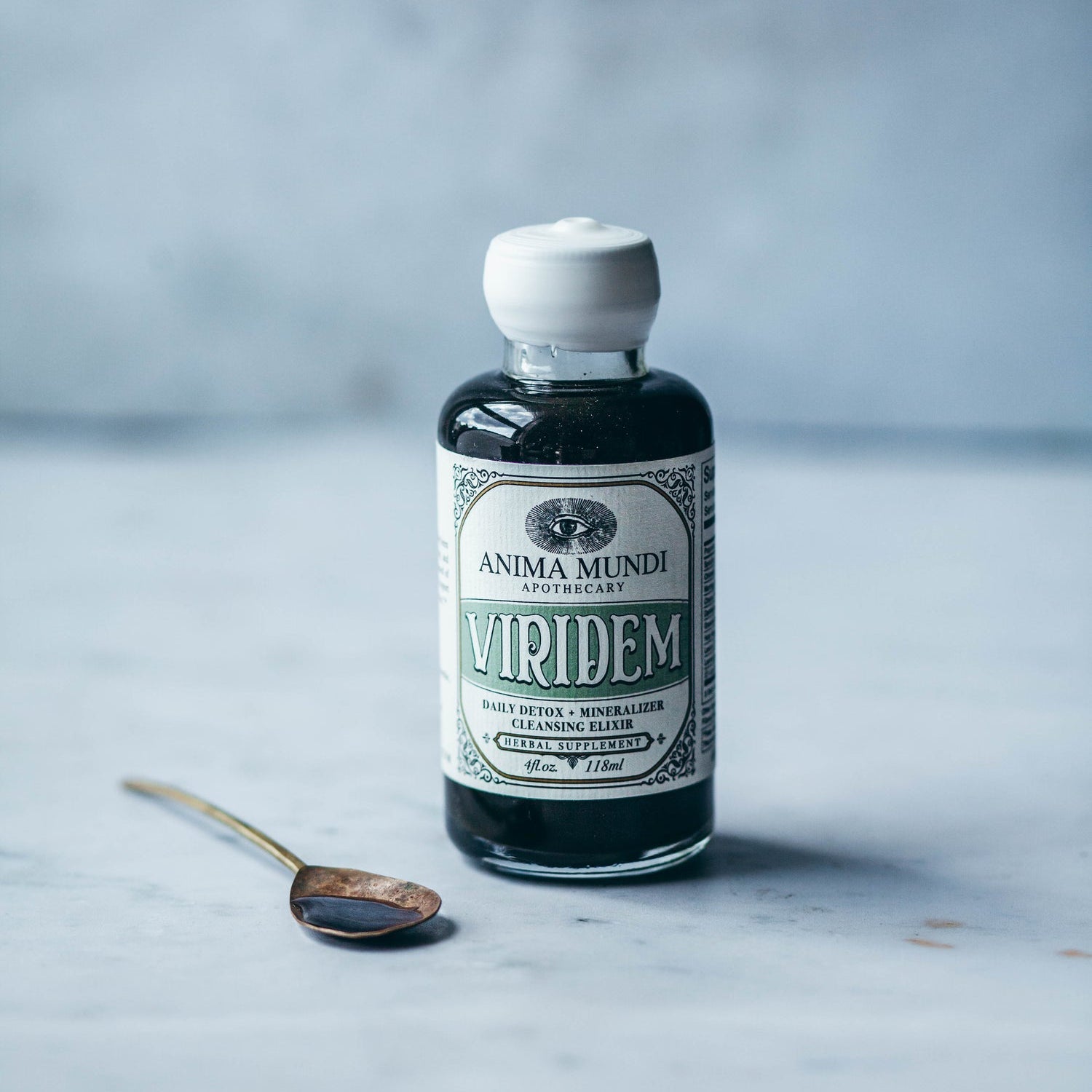 VIRIDEM Elixir bottle for daily detox support and mineralization with a spoon on a marble surface.