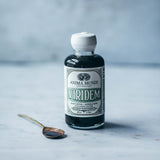 VIRIDEM Elixir bottle for daily detox support and mineralization with a spoon on a marble surface.