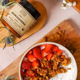 Bowl of granola with strawberries on a wooden board, featuring Ashwagandha product.