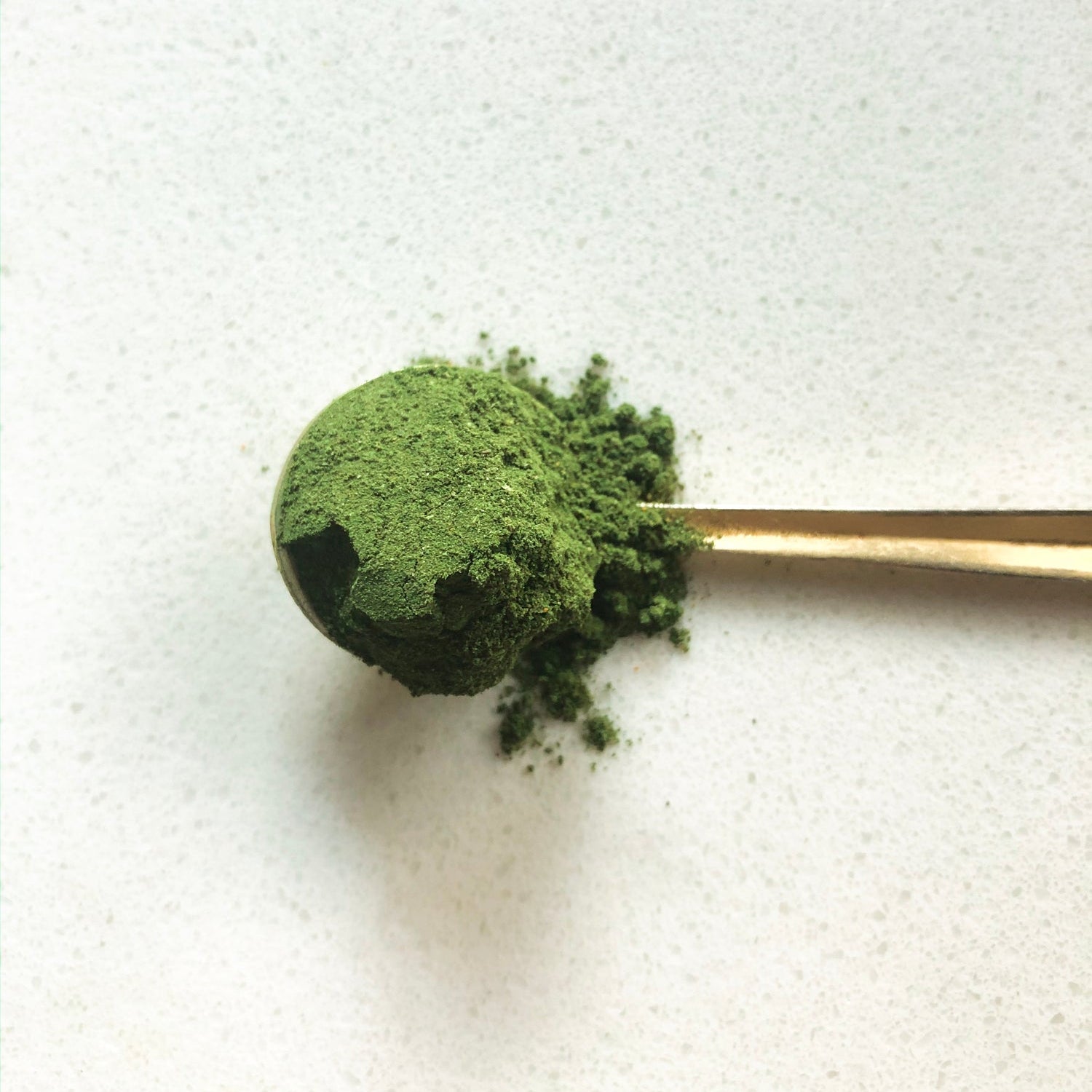 Spoonful of green powder for the Liver Vitality Greens daily cleansing powder to enhance liver health.