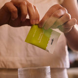 Person opening a packet of Sodii - Everyday Hydration Salts to mix with water for hydration.