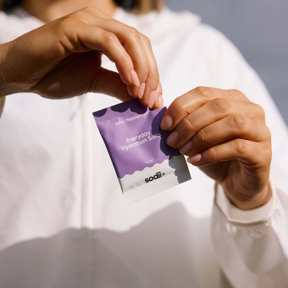 Person holding a packet of Sodii - Everyday Hydration Salts, designed for effective hydration with natural electrolytes.