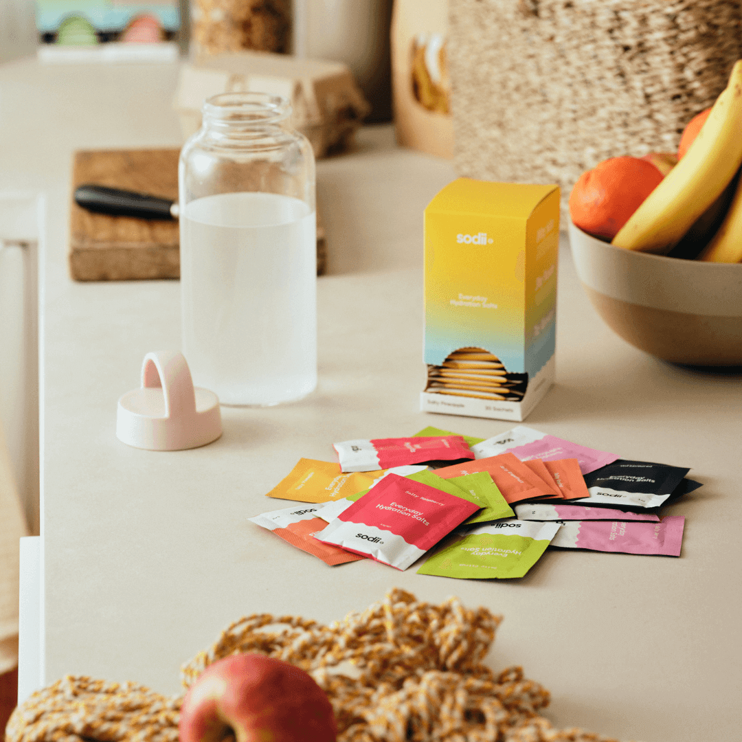 Everyday Hydration Salts Raspberry by Sodii displayed on a kitchen counter with water and fruits.