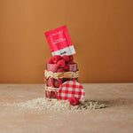 Everyday Hydration Salts Raspberry package displayed with raspberries in a basket on a sandy surface.